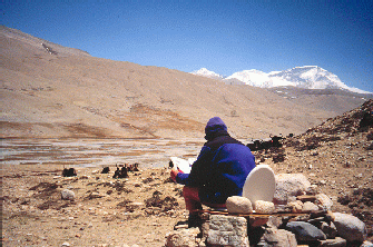 Sitting on the latrene reading the paper, with Cho Oyo in the background